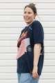 Person wearing an upcycled t-shirt featuring lots of different logos, made in canada