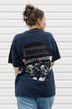 Person wearing an upcycled t-shirt featuring lots of different logos, made in canada