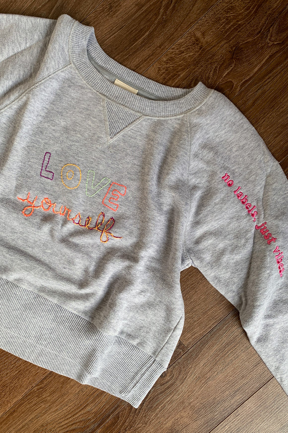 grey upcycled sweater with 'love yourself' embroidered detail, repurposed secondhand clothing