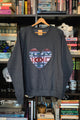 Person wearing a dark gray sweatshirt with a colorful heart design sewn in canada