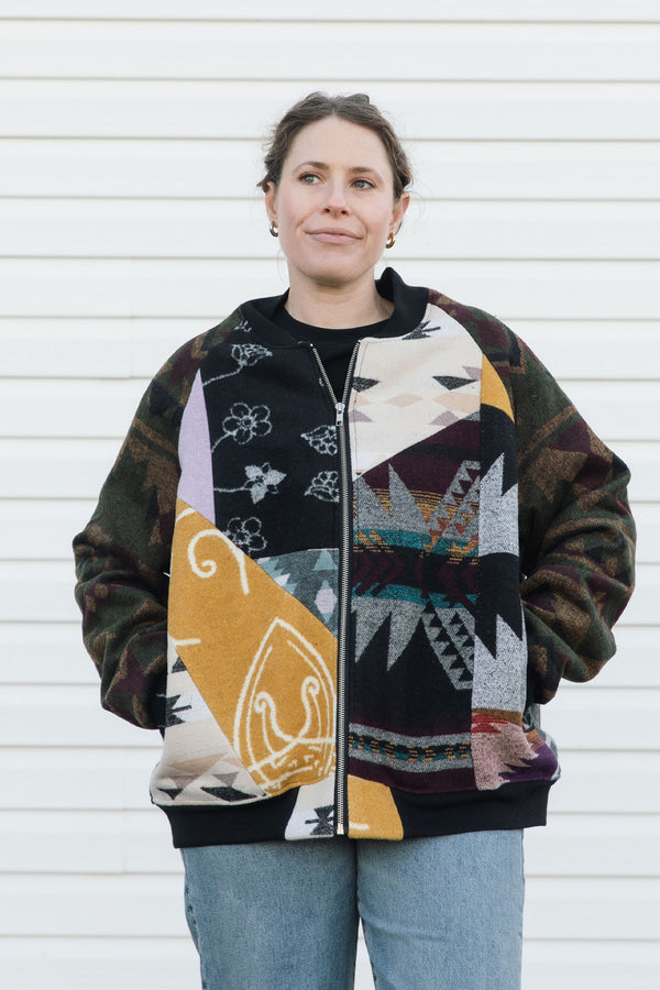 Person wearing a colorful patterned jacket against a white background