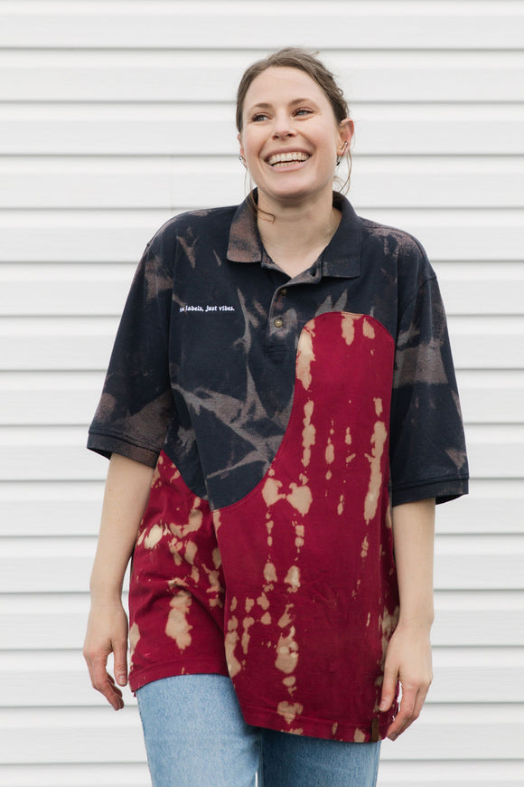 Woman wearing a navy and red patterned polo shirt against a white background