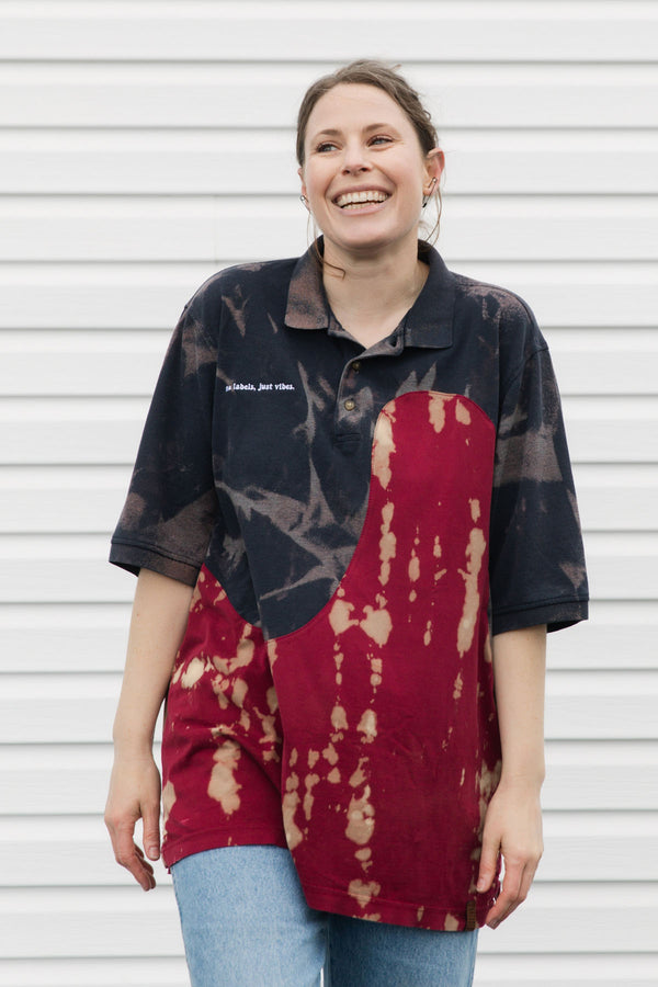 Woman wearing a navy and red patterned polo shirt against a white background