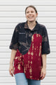 Woman wearing a navy and red patterned polo shirt against a white background