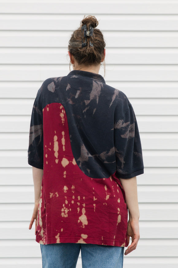 Woman wearing a navy and red patterned polo shirt against a white background