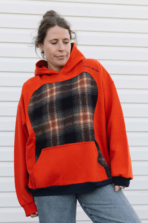 orange hoodie with navy cuffs and a black and brown plaid front, upcycled in canada