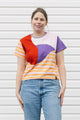 Woman wearing a colorful geometric-patterned shirt against a white background