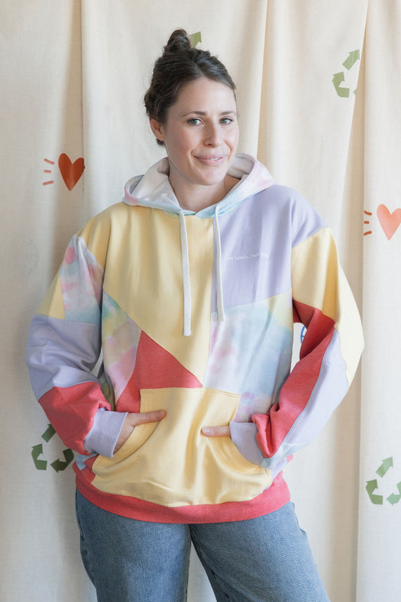 Woman wearing a colourful geometric-patterned hoodie upcycled in canada
