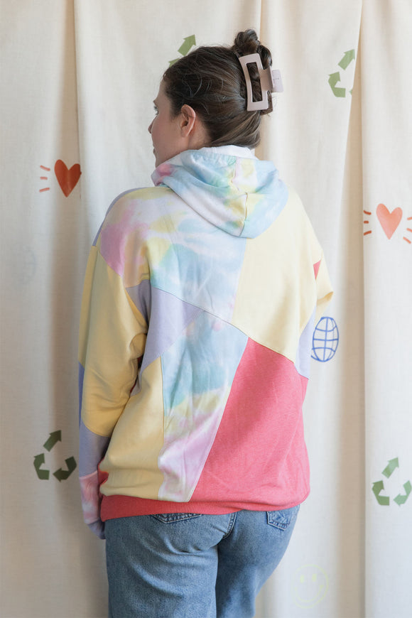 Woman wearing a colourful geometric-patterned hoodie upcycled in canada