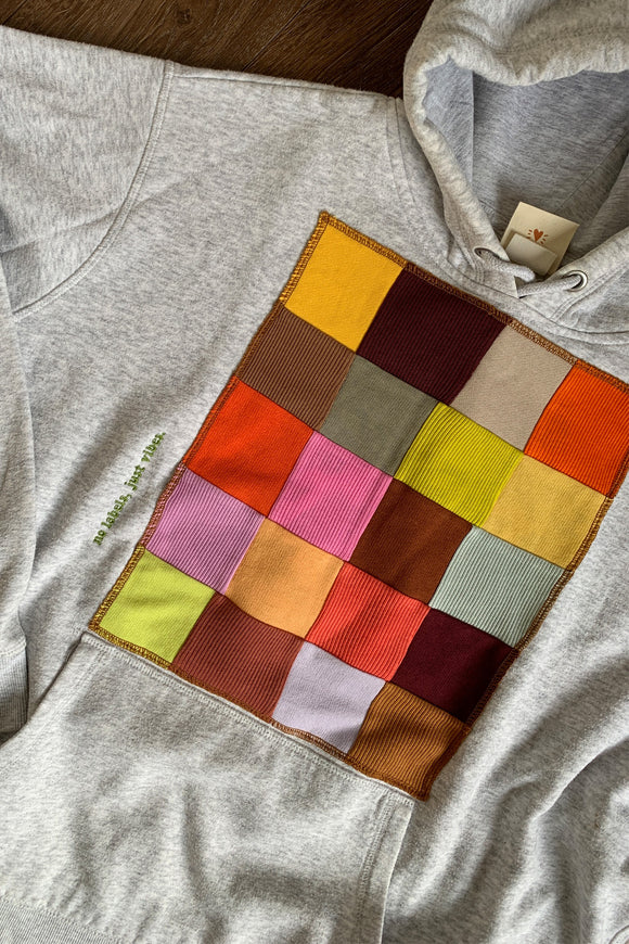 upcycled grey hoodie, with colourful patchwork motif on the front, repurposed in canada
