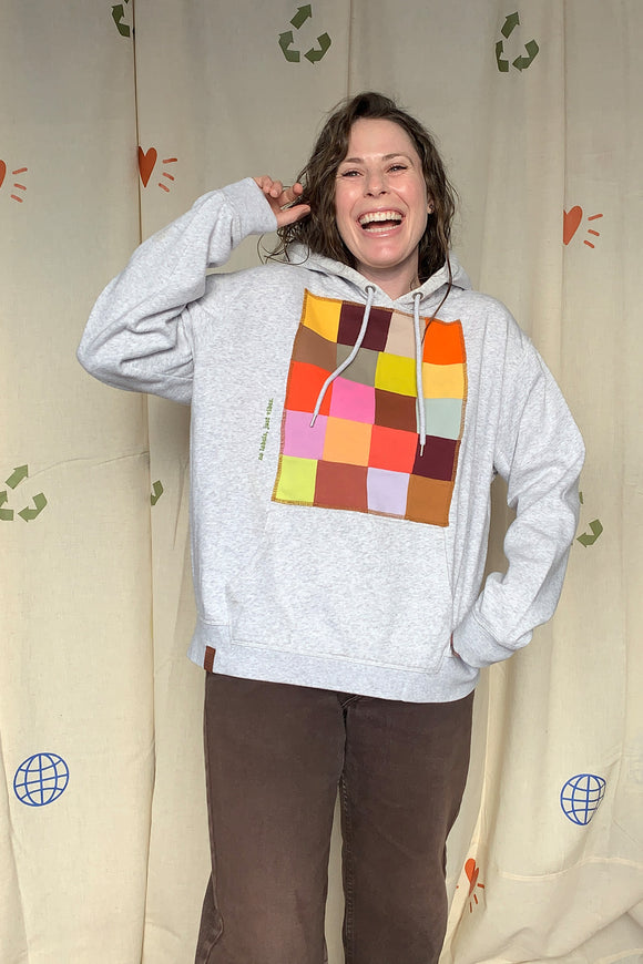 upcycled grey hoodie, with colourful patchwork motif on the front, repurposed in canada