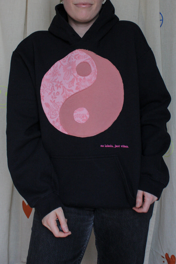 black hoodie with pink yin yang symbol, no labels, just vibes embroidery upcycled clothing, repurposed clothing, handmade in canada