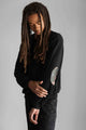 person wearing cotton oversized sweater with faux leather floral elbow patch. handmade in Ottawa
