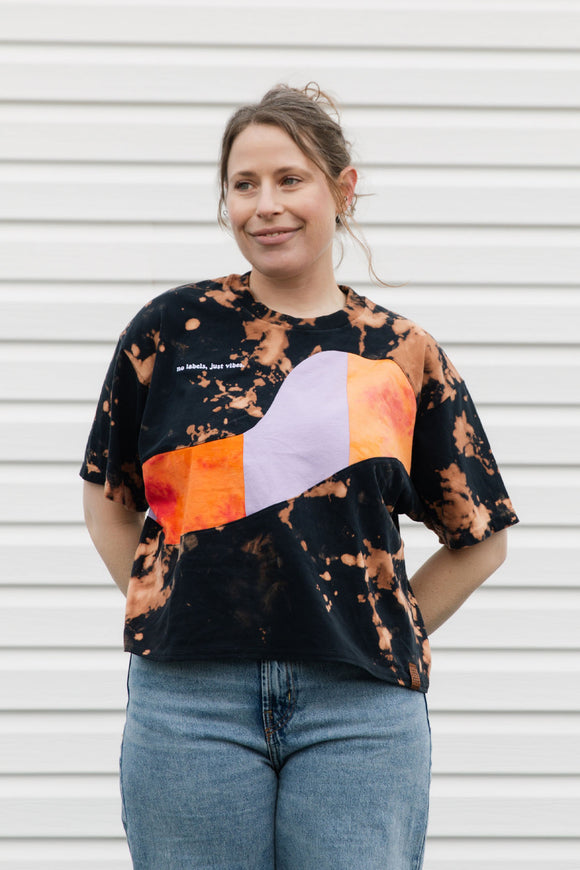 Person wearing a tie-dye shirt with purple and orange details, upcycled in canada