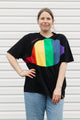 Person wearing a black t-shirt with a rainbow design in front of a white background