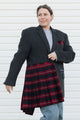 Woman wearing a gray coat with a red plaid skirt against a white background
