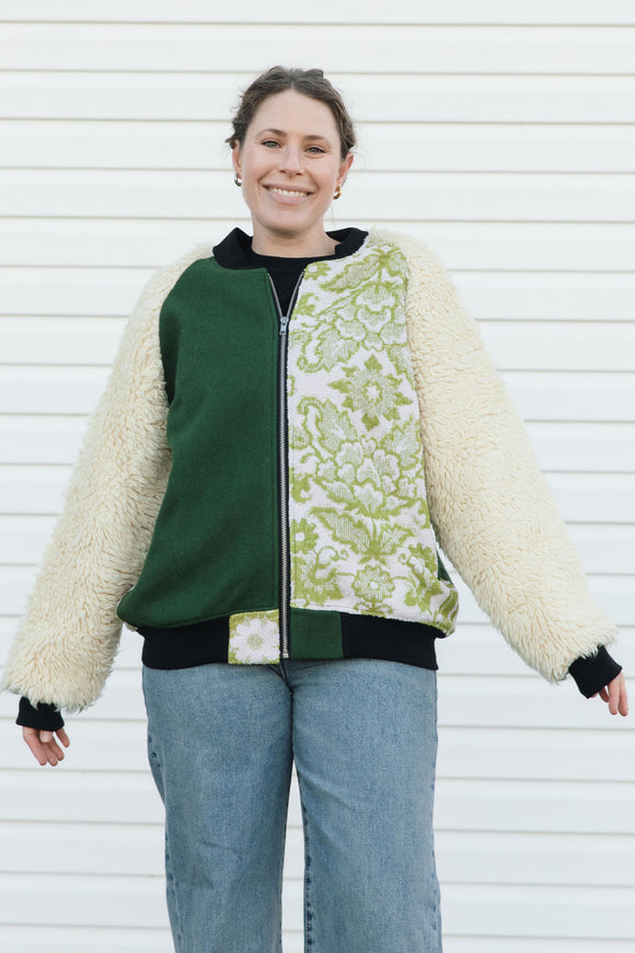 Person wearing a green and white patterned jacket with shaggy sleeves, upcycled in canada