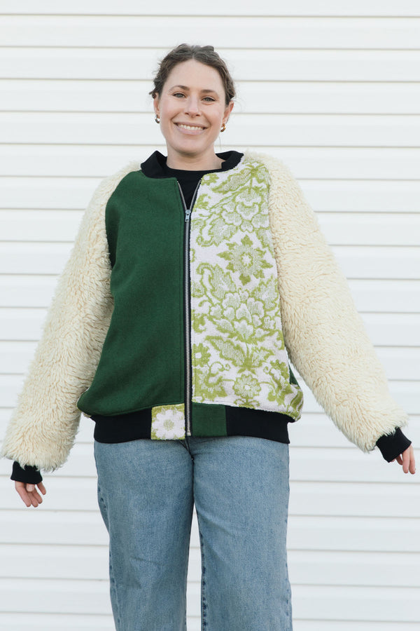 Person wearing a green and white patterned jacket with shaggy sleeves, upcycled in canada