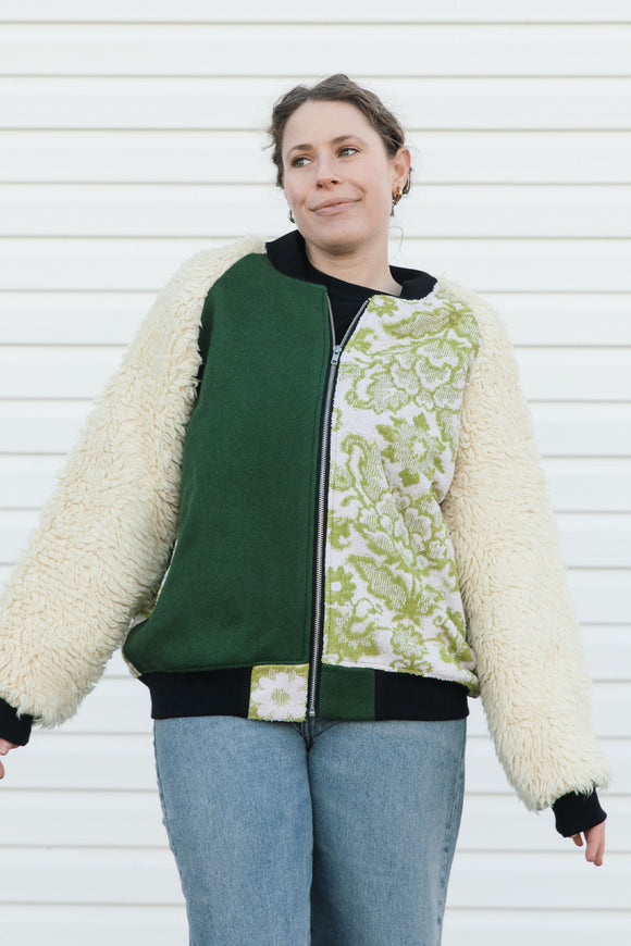Person wearing a green and white patterned jacket with shaggy sleeves, upcycled in canada