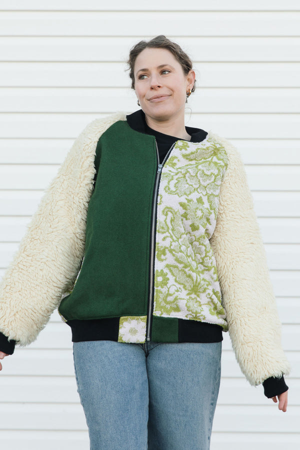 Person wearing a green and white patterned jacket with shaggy sleeves, upcycled in canada