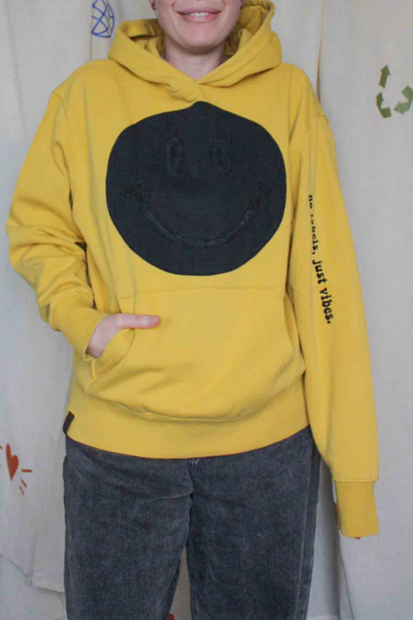 yellow hoodie with black smiley face on it, upcycled clothing