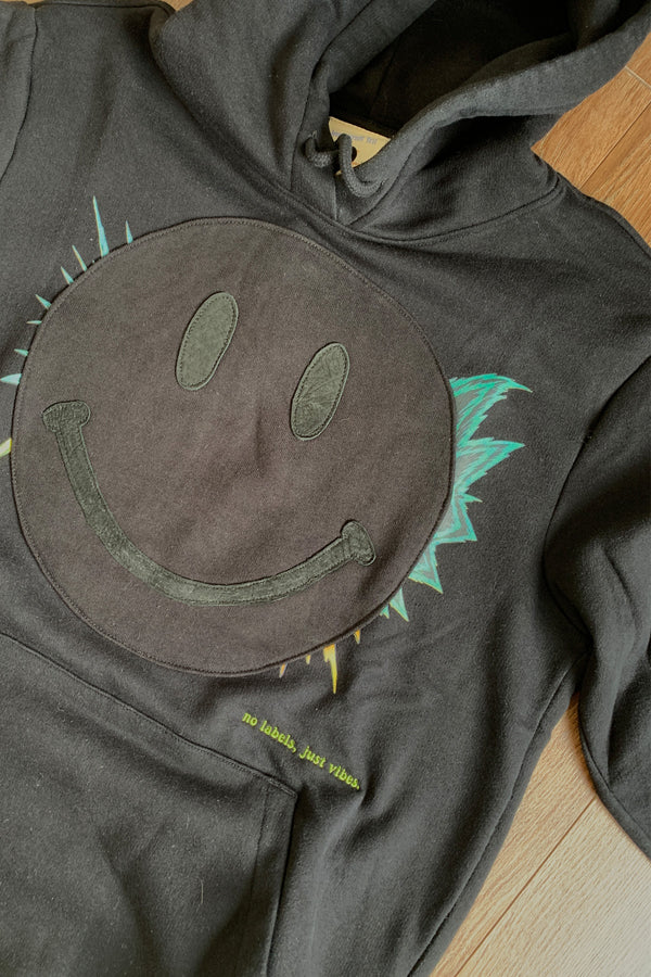 black hoodie with black smiley face on the front, upcycled and repurposed in canada