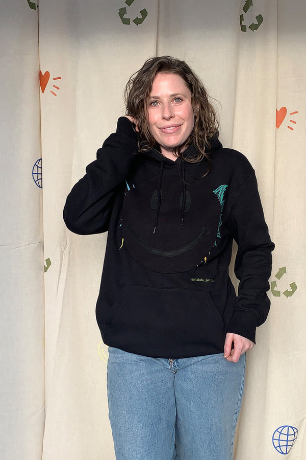 black hoodie with black smiley face on the front, upcycled and repurposed in canada