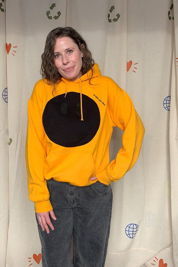 yellow hoodie with black smiley face on the front, repurposed and upcycled in canada
