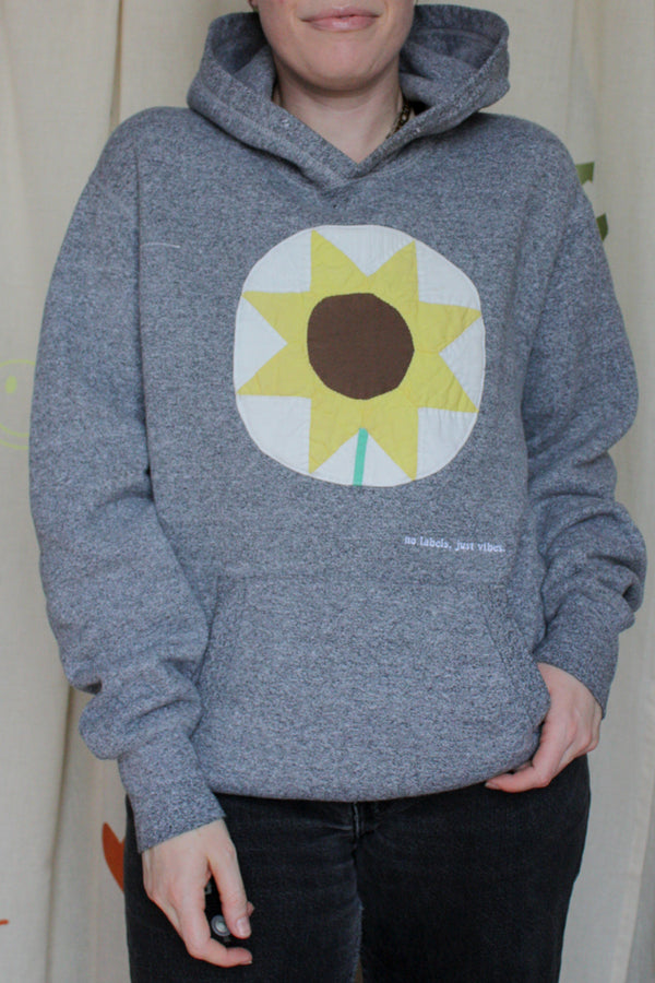 grey hoodie with sunflower motif, covering logo, repurposed clothing, upcycled, one of a kind, no labels, just vibes
