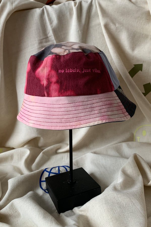 colourful upcycled bucket hat, each embroidered with 'no labels, just vibes.' and are reversible with solid colours, made in canada