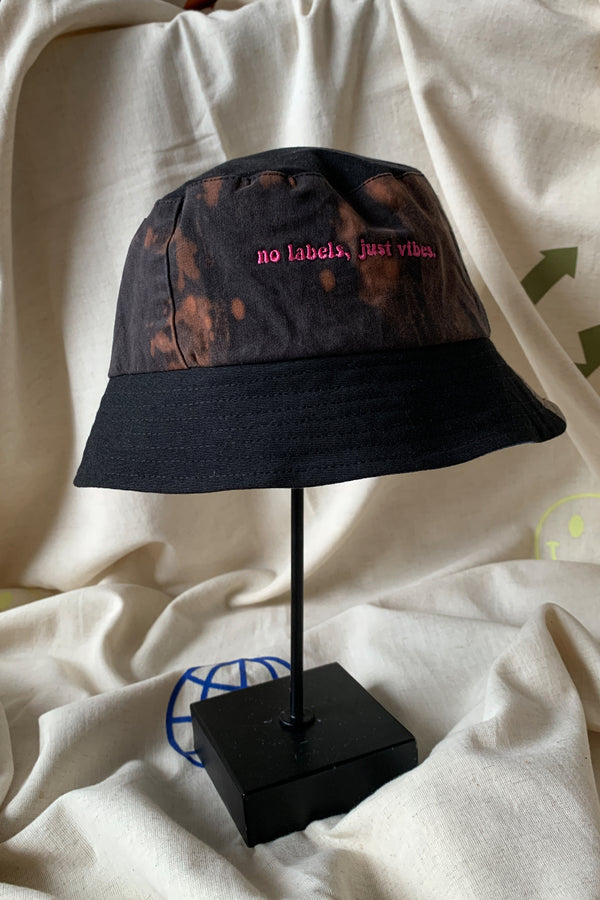 colourful upcycled bucket hat, each embroidered with 'no labels, just vibes.' and are reversible with solid colours, made in canada