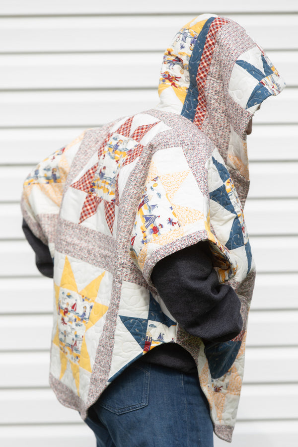 yellow and red star quilt upcycled into clare poncho, featuring a big hood, pockets and oversized style, upcycled and made in canada