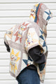 yellow and red star quilt upcycled into clare poncho, featuring a big hood, pockets and oversized style, upcycled and made in canada