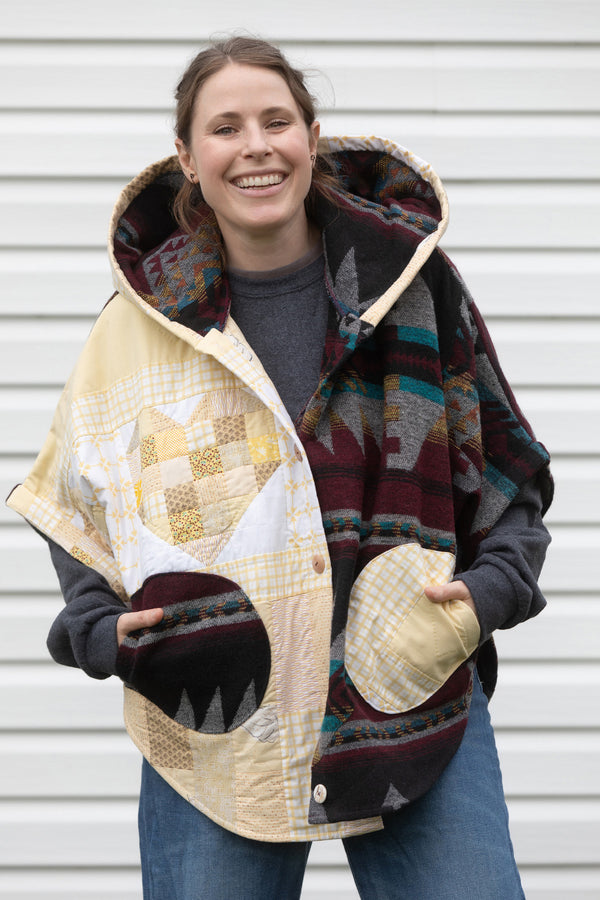 oversized upcycled quilted poncho, made from scrap fabric, yellow quilt with burgundy patterned fabric, repurposed in canada