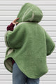 person wearing green wool poncho with oversized hood and fit, featuring pocket up and button up front, upcycled in canada