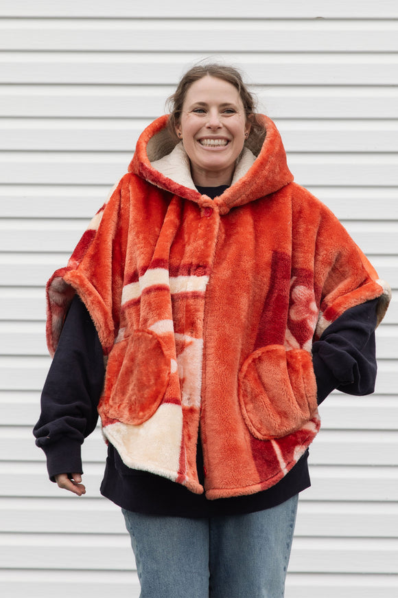 plush orange floral blanket upcycled in to stunning oversized poncho featuring a hood, pockets and button up front, repurposed in canada