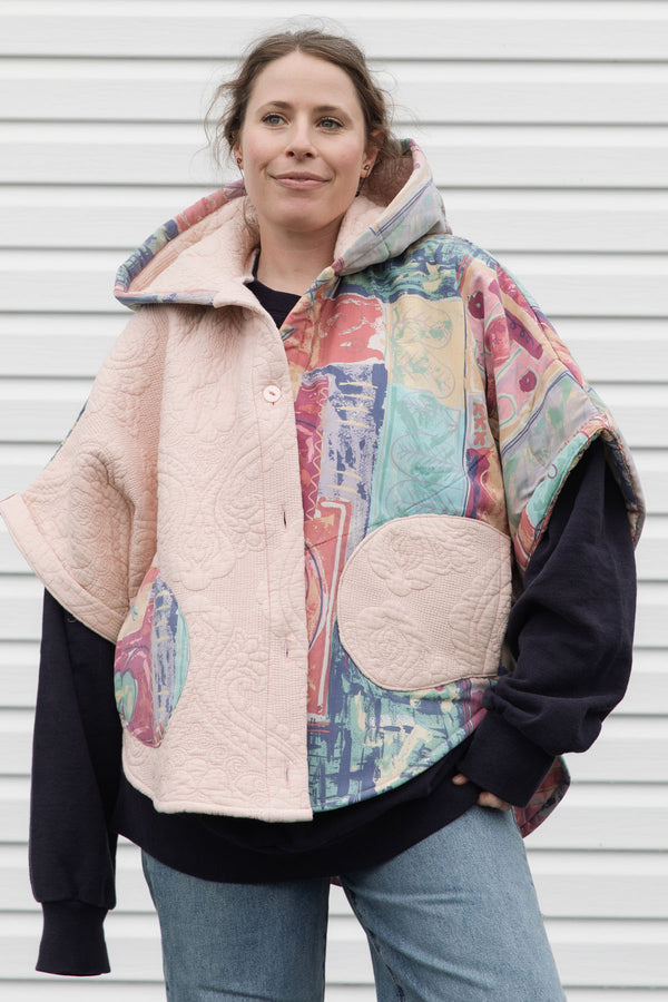 pink quilt and colourful comforter upycled into stunning oversized poncho featuring a hood, pockets and button up front, repurposed in canada