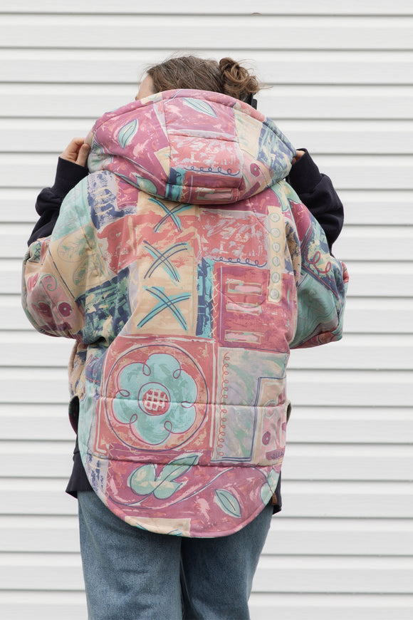 pink quilt and colourful comforter upycled into stunning oversized poncho featuring a hood, pockets and button up front, repurposed in canada