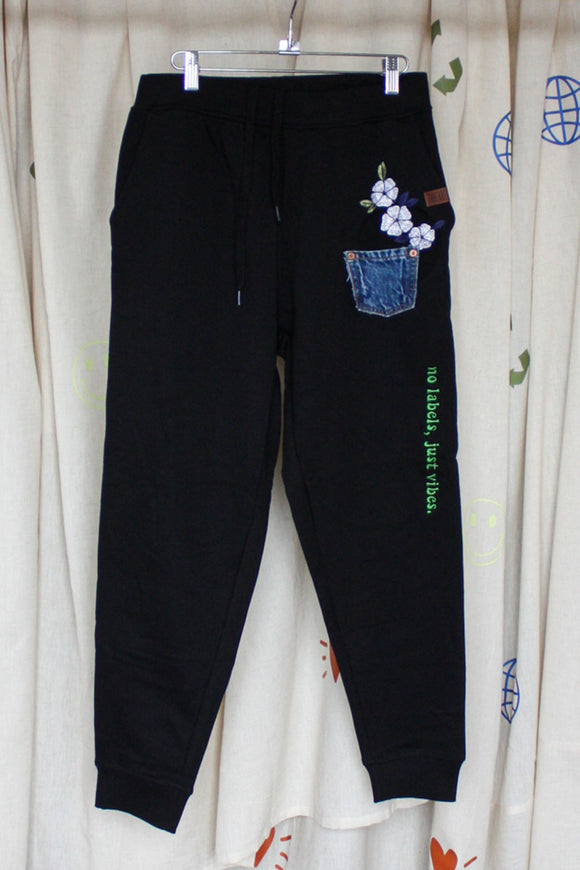 black jogging pants with denim patch pocket and floral embroidery, upcycled clothing, no labels, just vibes